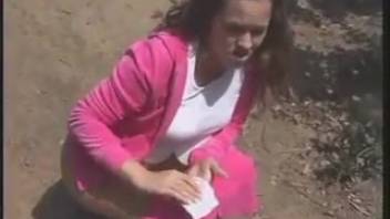 The young woman in pink defecating on the tree stump